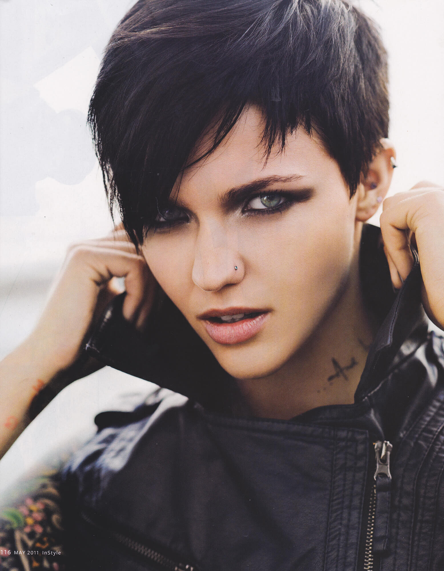 Close-up portrait of a young adult woman with short dark hair, smokey eyes, and a leather jacket, looking directly at the camera.
