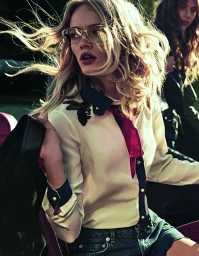 Blonde model with glasses wearing off-white blouse and dark shorts holding jacket, styled by Julianne Mcguigan in Sydney.