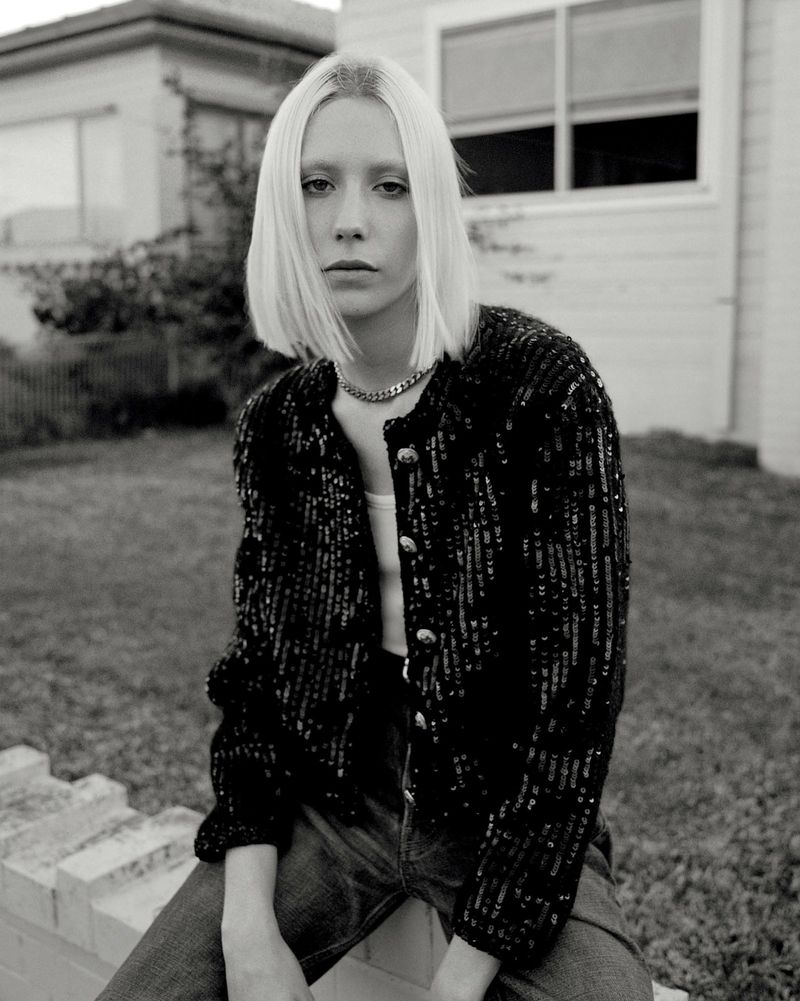 Black and white portrait of a blonde woman wearing a sequined jacket outdoors in Sydney styled by Naomi Smith.