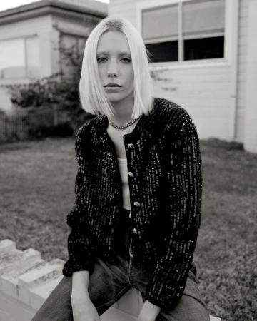 Black and white portrait of a blonde woman wearing a sequined jacket outdoors in Sydney styled by Naomi Smith.