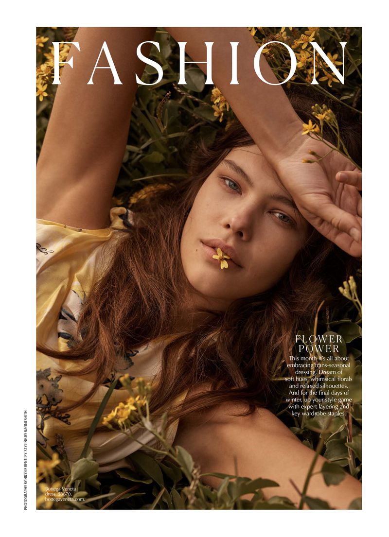 Fashion magazine cover featuring a young woman lying in greenery with a flower in her mouth and the title 'FASHION' at the top.