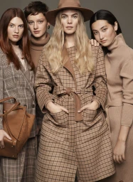 Group of four female models in neutral brown tones and plaid coats with a leather handbag against a grey backdrop