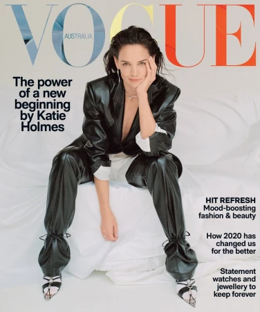 Katie Holmes seated wearing a black leather blazer and matching leather trousers against a white backdrop.