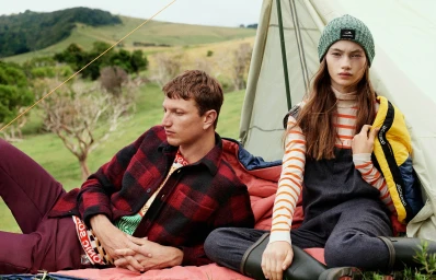 Man and woman camping outdoors near a tent, styled with hair by Michele McQuillan in Sydney.
