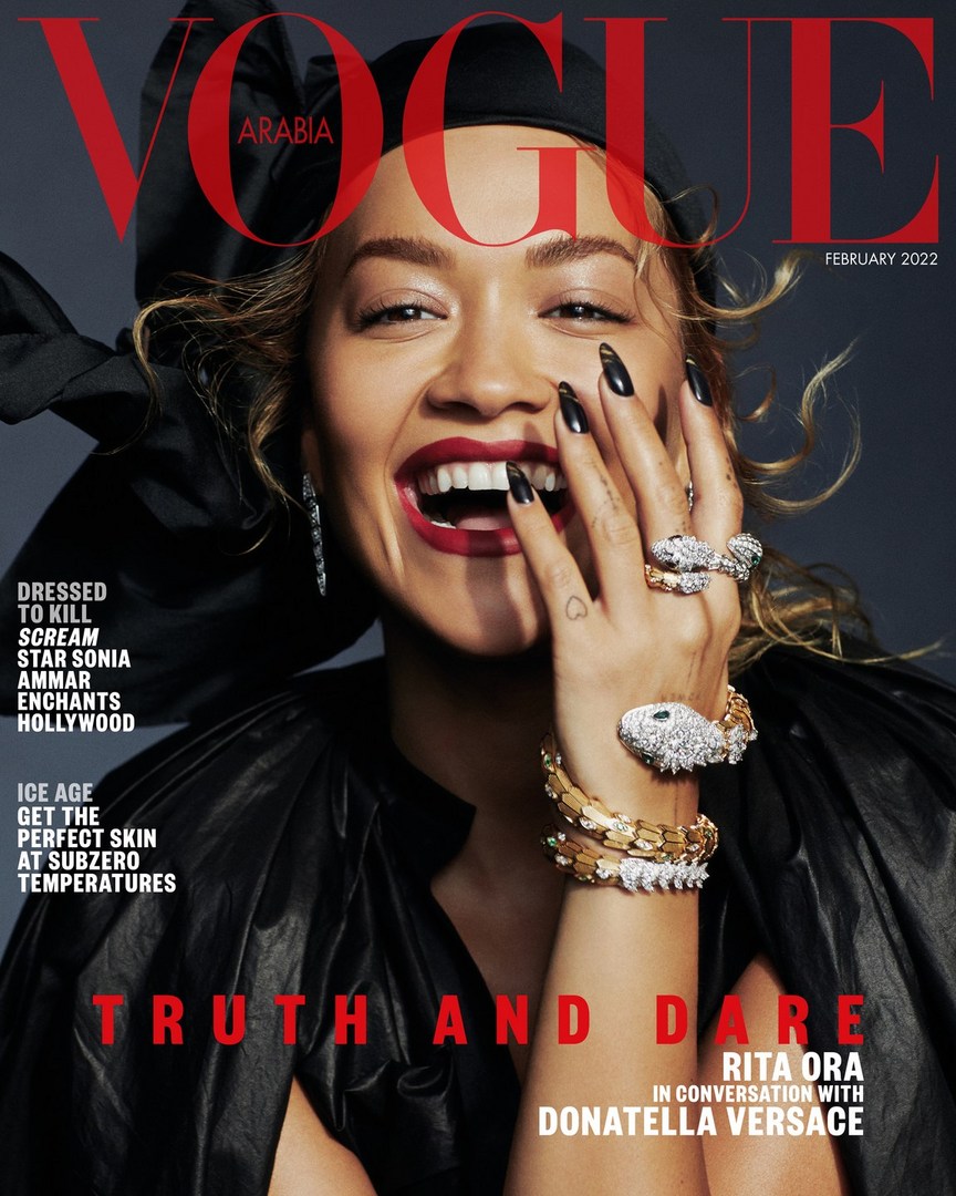 Vogue Arabia cover featuring Rita Ora with bold red lipstick, striking jewelry, and black formalwear against a grey backdrop.