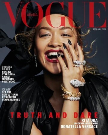 Vogue Arabia cover featuring Rita Ora with bold red lipstick, striking jewelry, and black formalwear against a grey backdrop.