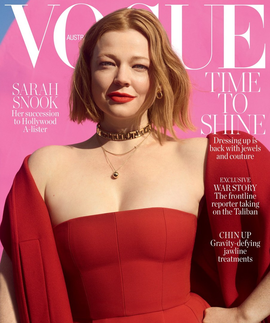 Sarah Snook appears on the cover of Vogue Australia, wearing a red dress and jewelry against a pink background.