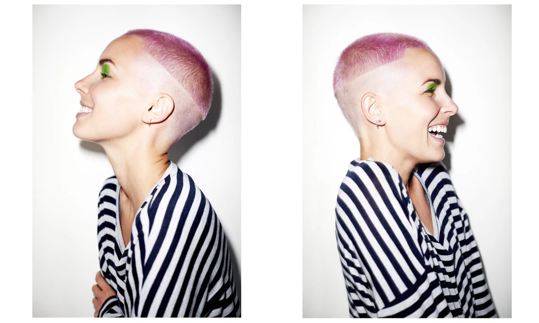 Smiling woman in striped top with pink hair and green eyeshadow against a white background in a side profile and portrait split.