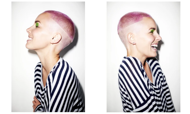 Smiling woman in striped top with pink hair and green eyeshadow against a white background in a side profile and portrait split.