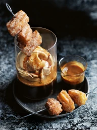 Affogato in a glass with cinnamon sugar churro skewers styled by Steve Pearce against a dark mottled background