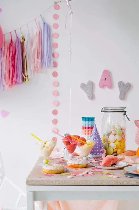 Party table styled with desserts, ice cream, doughnuts, a candy jar, and pastel decorations by Olivia Blackmore