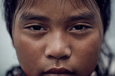 Close-up portrait of a young person with wet skin and damp dark hair framing the face by photographer Sean Izzard