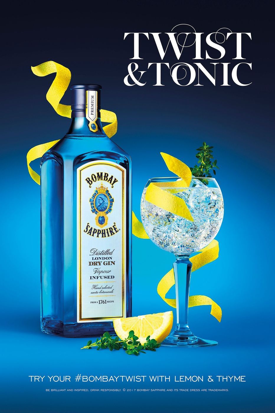 Bombay Sapphire gin bottle and a gin and tonic drink with lemon and thyme on a blue background.