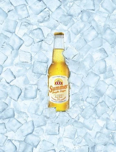 A bottle of XXXX Summer Bright Lager beer is positioned amidst a bed of ice cubes, suggesting a refreshing and cold beverage.