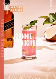 Pink cocktail in a tall flamingo glass next to a whisky bottle on marble surface