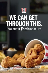 A bucket of fried chicken pieces spilling onto a wooden table with text overlay reading WE CAN GET THROUGH THIS