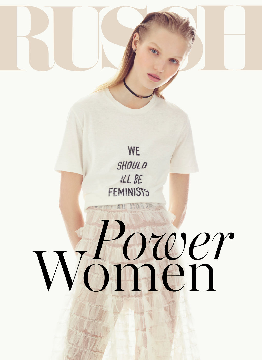Young adult female poses in a fashion editorial shot wearing a t-shirt with text and a ruffled skirt against a white backdrop. 