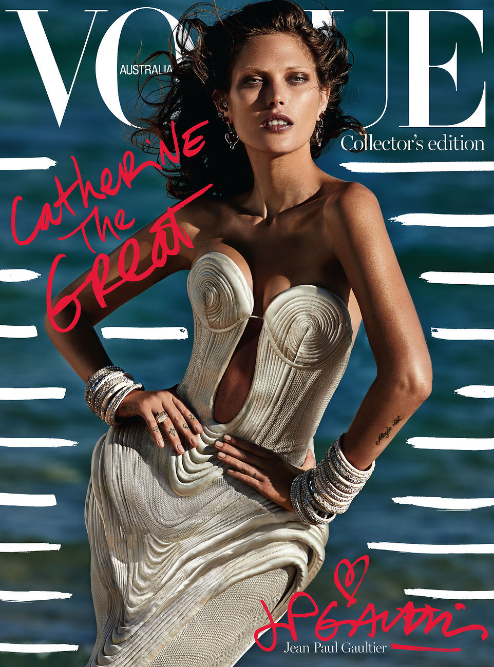 Vogue Australia cover featuring an adult woman in a sculptured gown and multiple bracelets, posing on a beach with ocean backdrop.