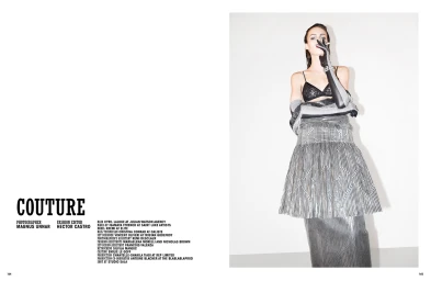 Model wearing black lace bralette and patterned metallic skirt with long opera gloves against white background