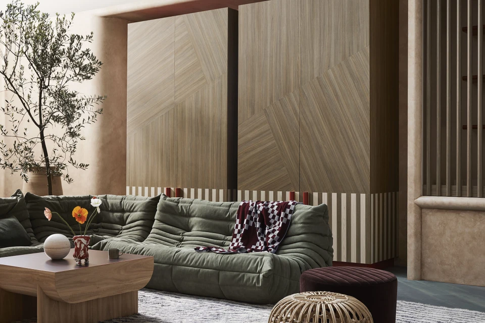 Contemporary living room interior featuring a green sofa, wooden cabinets, and decorative elements, creating a stylish and inviting space.