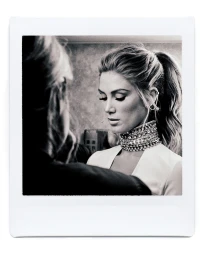 Monochrome backstage polaroid of a woman wearing a heavy jeweled choker necklace, styled by Jana Bartolo.