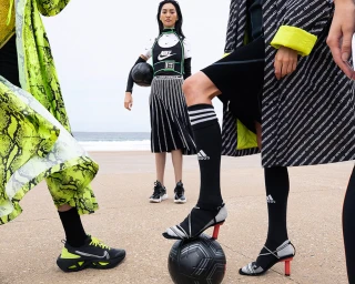 Group of models posing outdoors on a sandy beach with soccer balls, styled by Jana Bartolo
