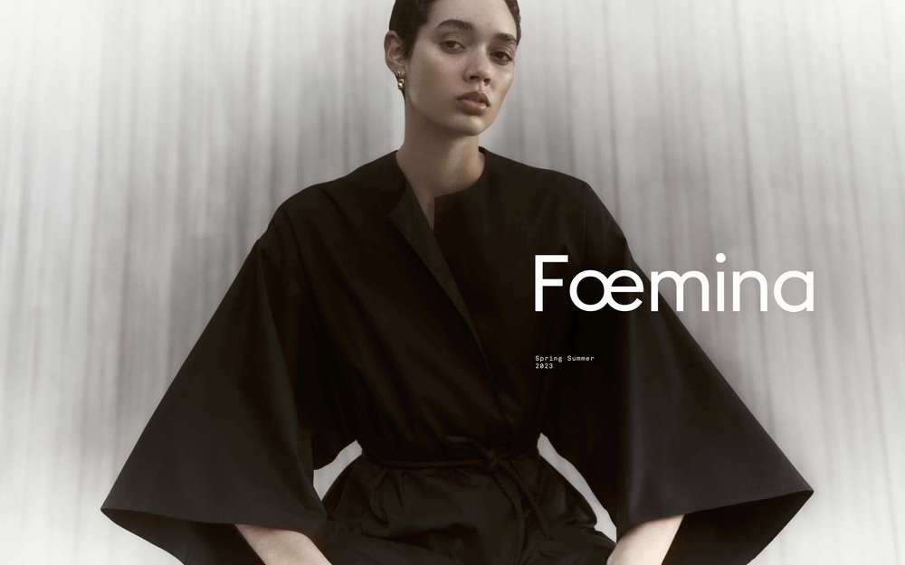 A woman poses in black attire against a bright background, featuring the 'Faemina Spring Summer 2023' campaign. Fashion photography.