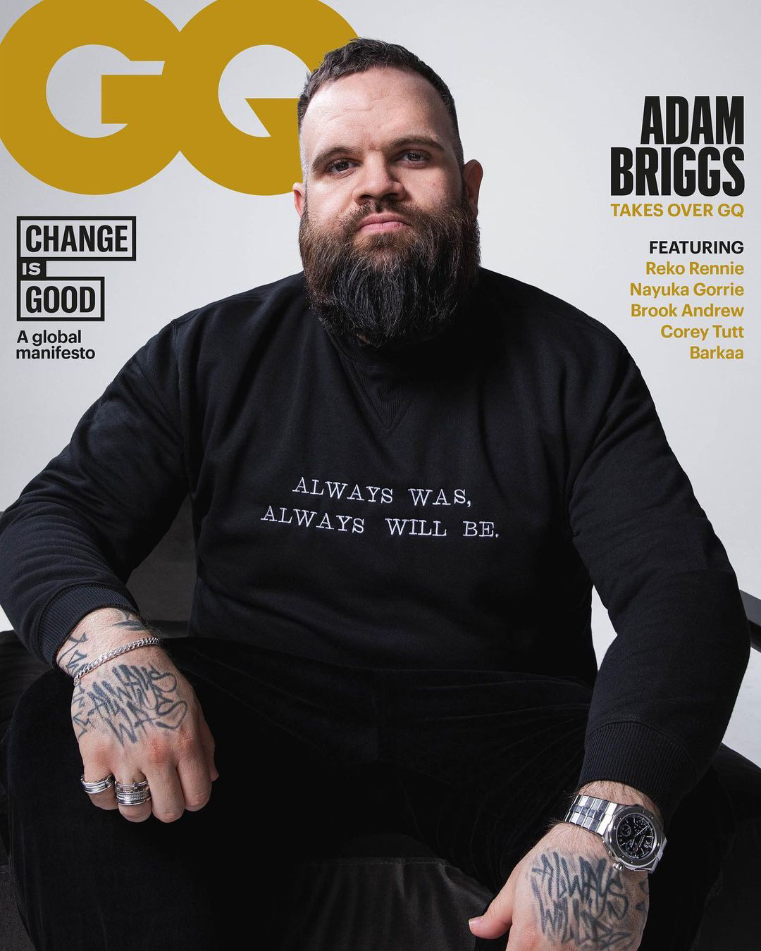 Adam Briggs poses for GQ cover with a beard, black sweater, and visible tattoos. The GQ logo and cover text are prominent.