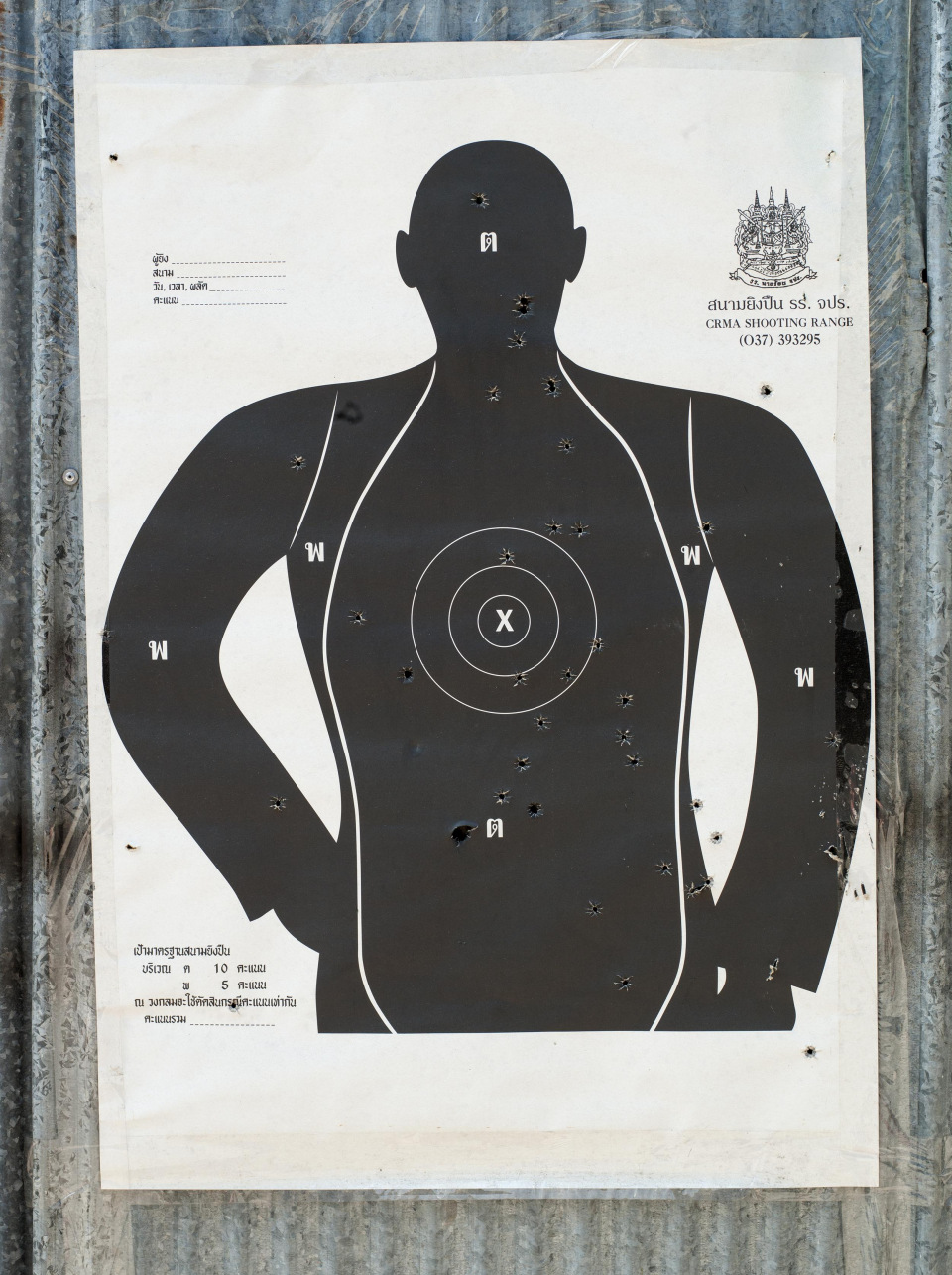 Silhouette of a shooting target with bullet holes against a textured wall, showcasing a focus on target practice and shooting range imagery.
