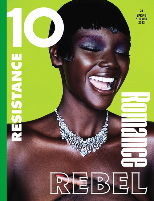 Magazine cover featuring a smiling Black female model with short hair, wearing a diamond necklace and bright eyeshadow against a lime green background.