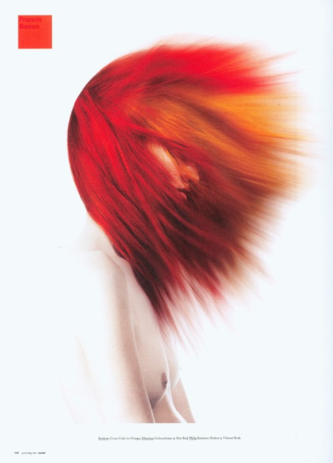 Artistic fashion portrait of a model with vibrant red and orange hair, captured in a soft, diffused light against a white backdrop.