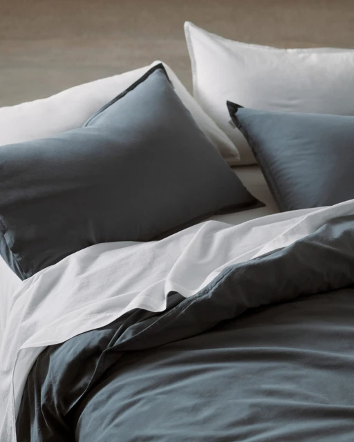 Bedroom interior featuring a bed with blue and white bedding, including pillows and duvet cover, creating a cozy and inviting atmosphere.