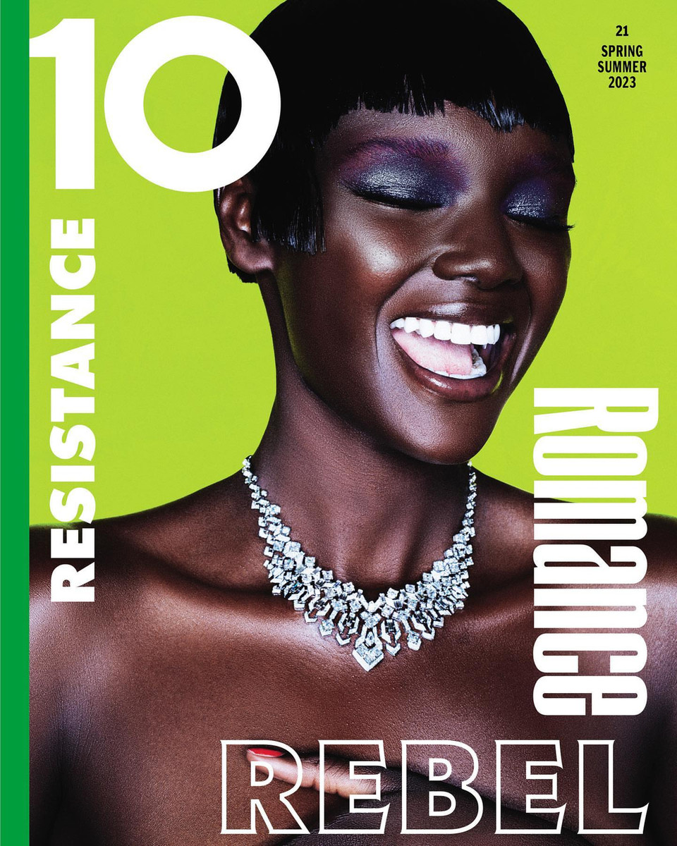 Magazine cover featuring a Black female model with short dark hair, bold eye makeup, and diamond necklace against a lime green background.