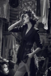 Black and white portrait of a woman with styled hair wearing a dark blazer with lace details outdoors in Sydney.