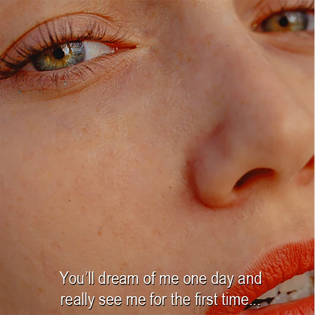 Close-up studio portrait of a woman with green eyes and red lipstick, showcasing details in beauty and skincare with natural lighting.