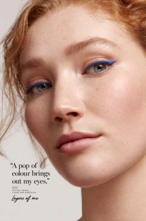 Close up beauty portrait of a red haired woman with blue eyeliner and visible freckles shot by Amelia Dowd