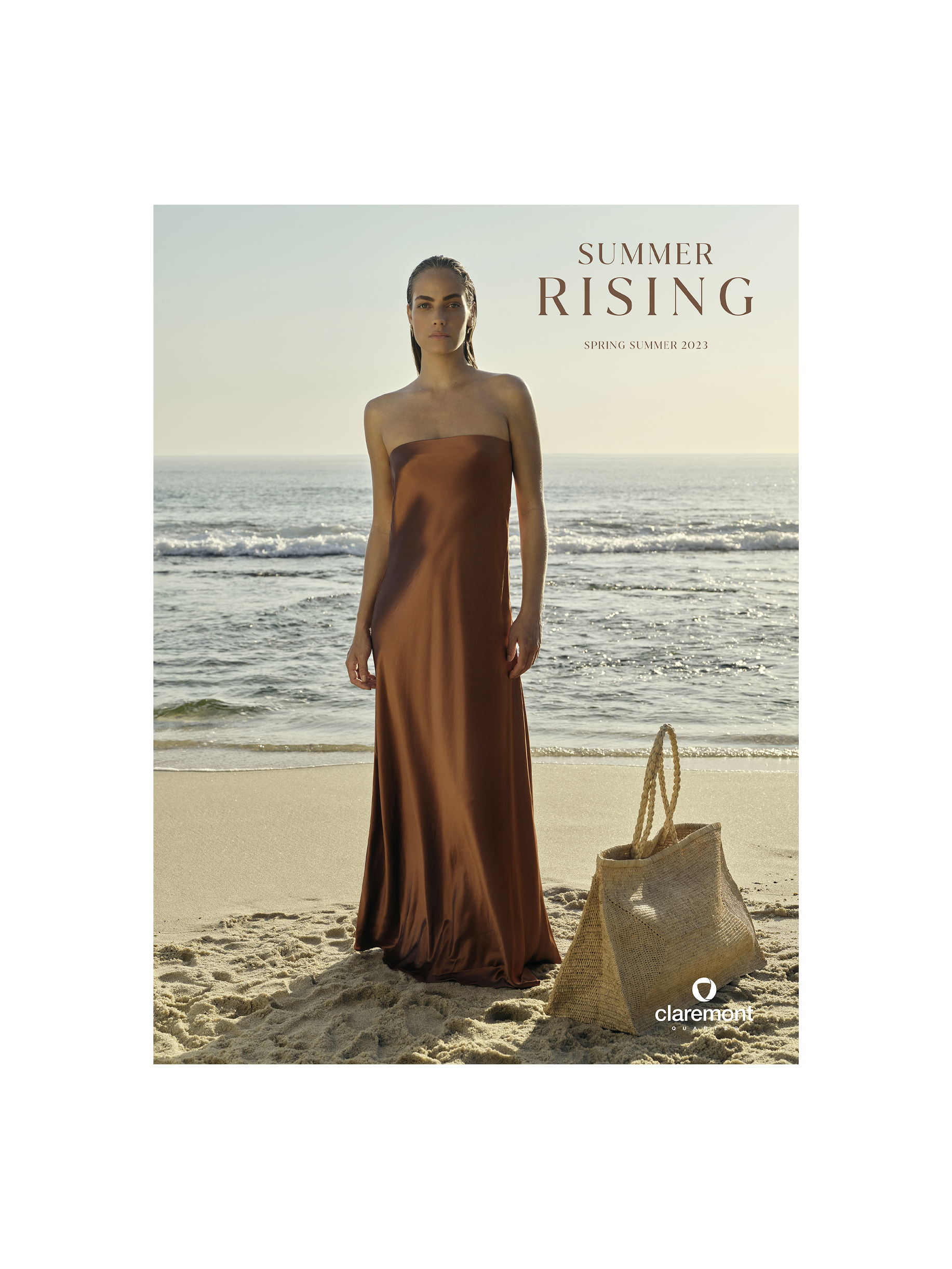 Elegant woman in a strapless dress on a beach at sunset, holding a straw bag. Soft, dreamy lighting, with ocean waves in the background.
