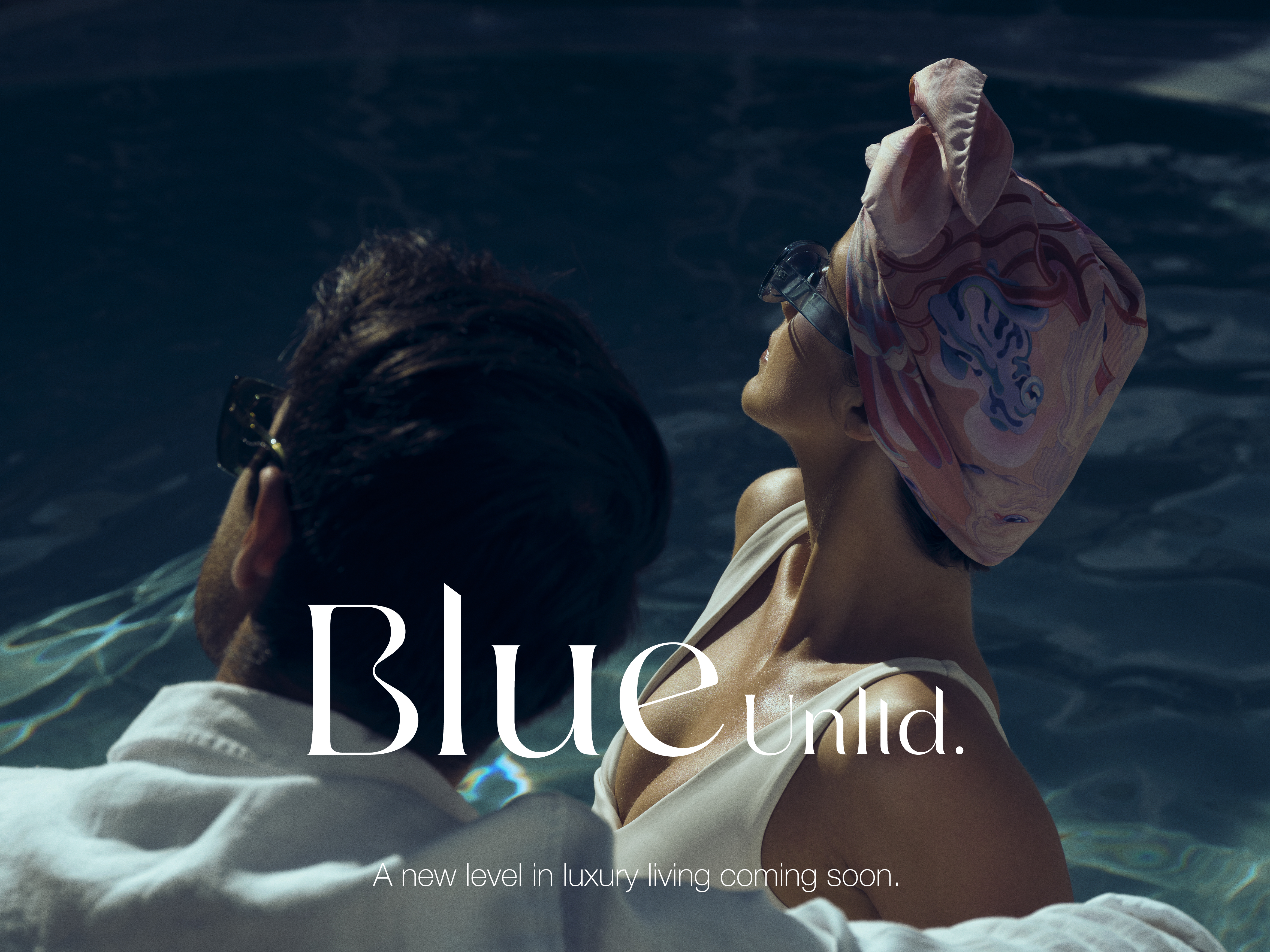 A man and a woman in a pool wearing sunglasses with the water reflecting sunlight, and promotional text for 'Blue Unltd.'
