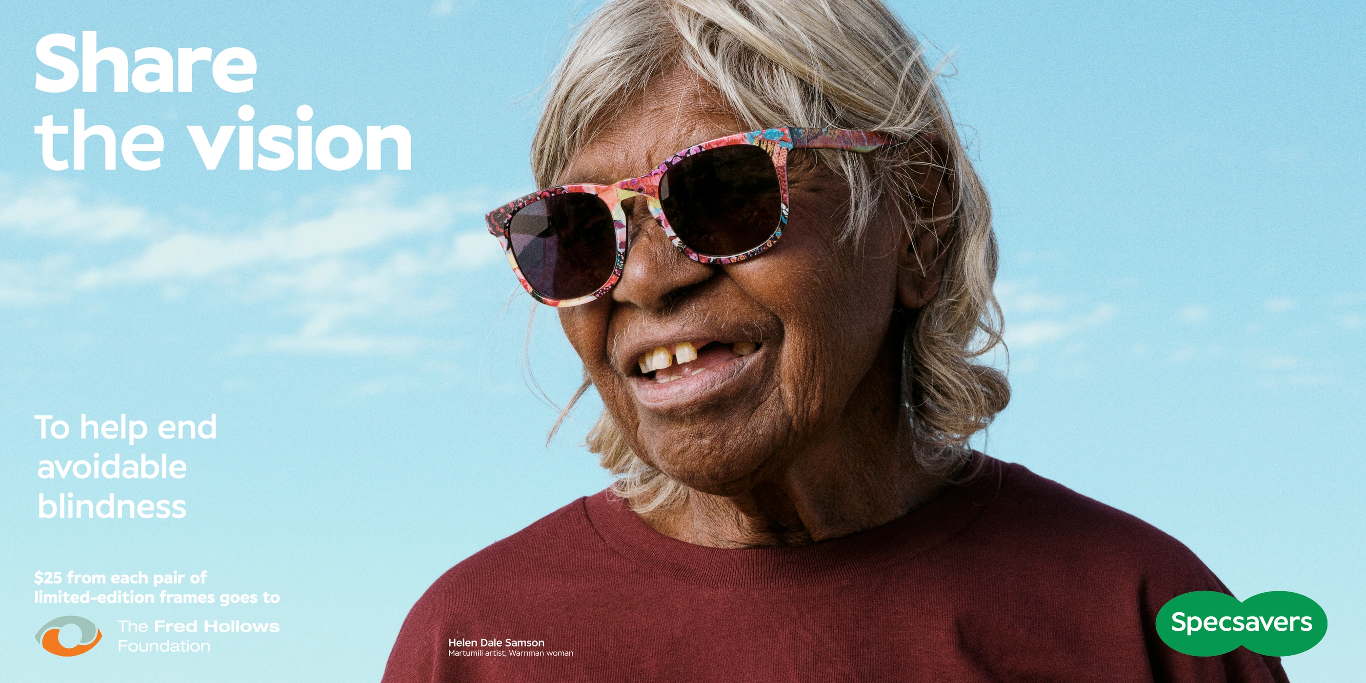 Elderly Indigenous woman wearing patterned sunglasses and a burgundy t-shirt against a clear blue sky background.
