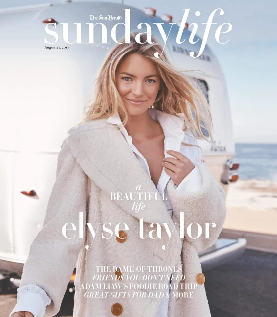 Magazine cover featuring Elyse Taylor in a stylish coat next to a silver vintage trailer. Editorial shot, warm colors.