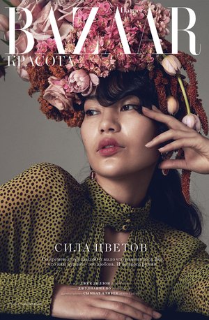 Magazine cover featuring a woman with floral headwear and a spotted top against a neutral background, showcasing beauty and fashion.