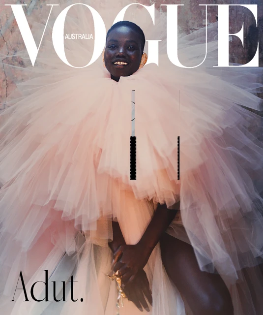 Vogue Australia cover featuring a Black female model in a voluminous pink tulle gown, smiling against a mottled backdrop with bold magazine typography.