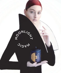 Model with red hair wearing a high-collared black garment holding a decorated candle jar by Pete Lennon