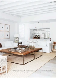Bright white living room interior styled by Kristin Rawson featuring a large wooden coffee table and white sofas on a neutral rug.