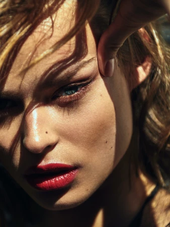 Close-up portrait of a woman with red lipstick and dramatic sunlight shadows across her face by Rayan Ayash