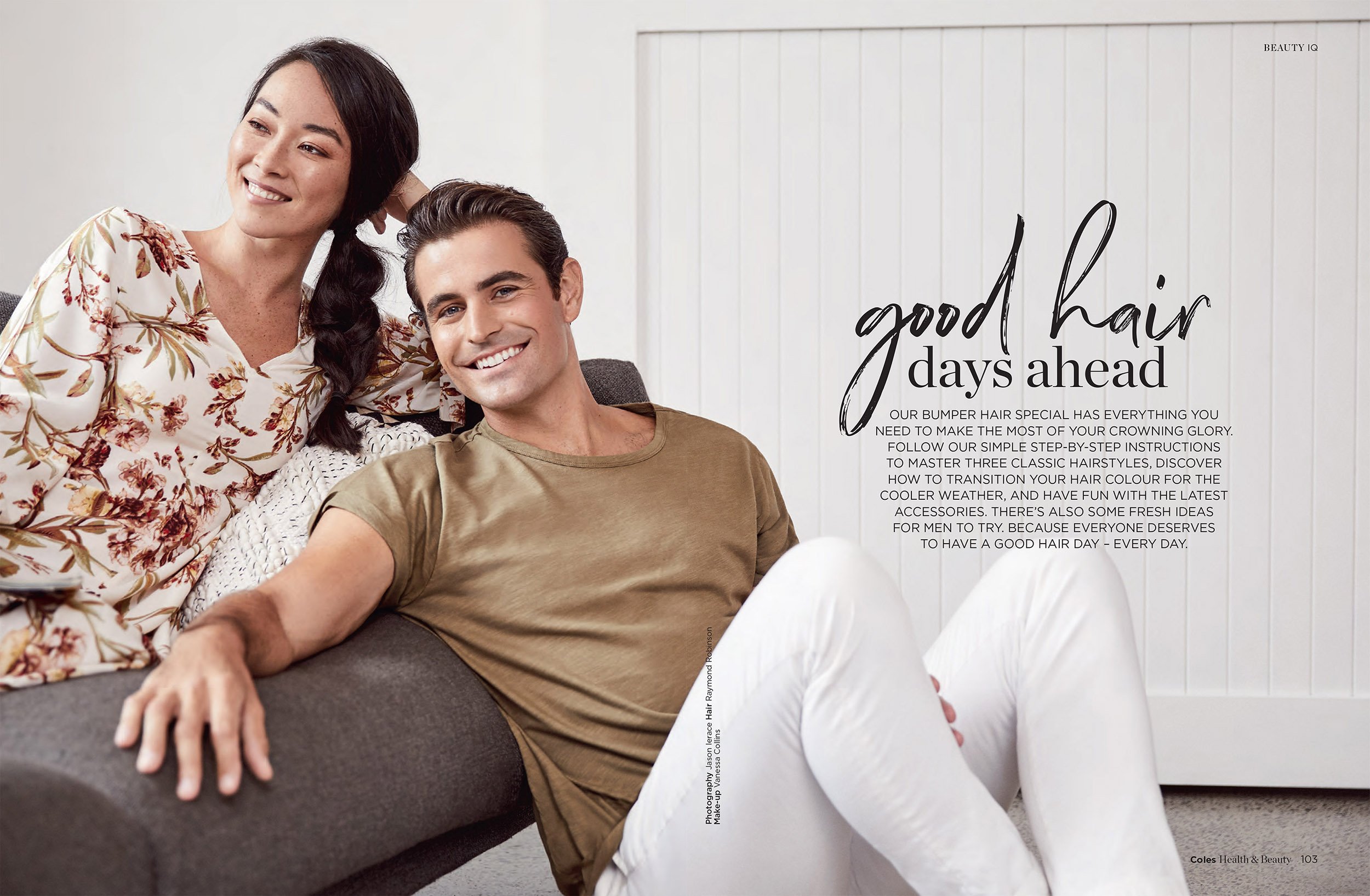 A man and a woman are sitting on a couch smiling indoors. The woman is wearing a floral shirt, and the man is in an olive t-shirt.