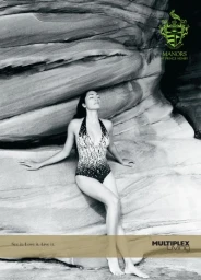 Black and white portrait of a woman wearing a patterned swimsuit leaning against textured rock formations.