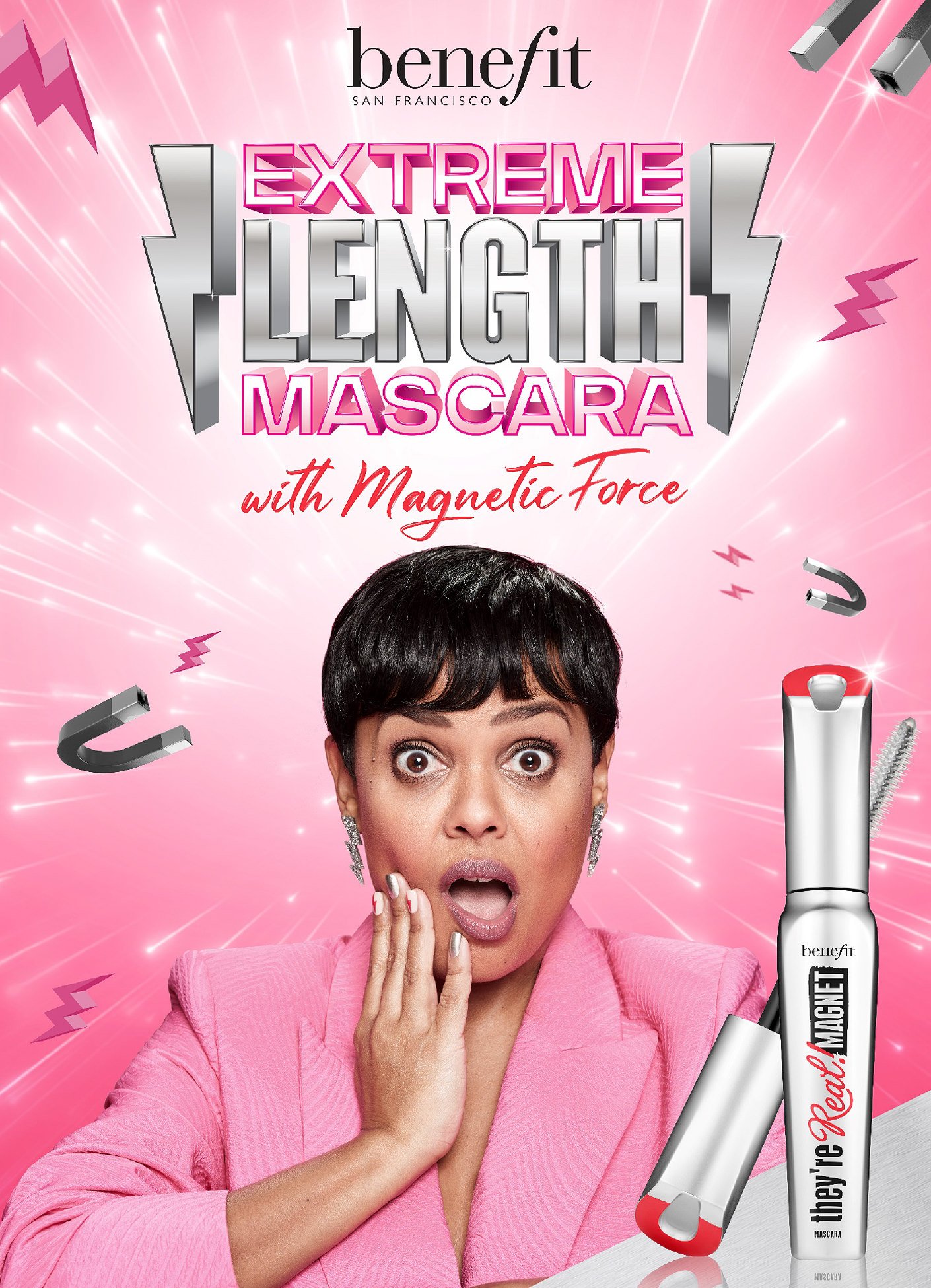 Benefit Cosmetics ad featuring a woman with an excited expression, promoting Extreme Length Mascara with Magnetic Force and cosmetics.
