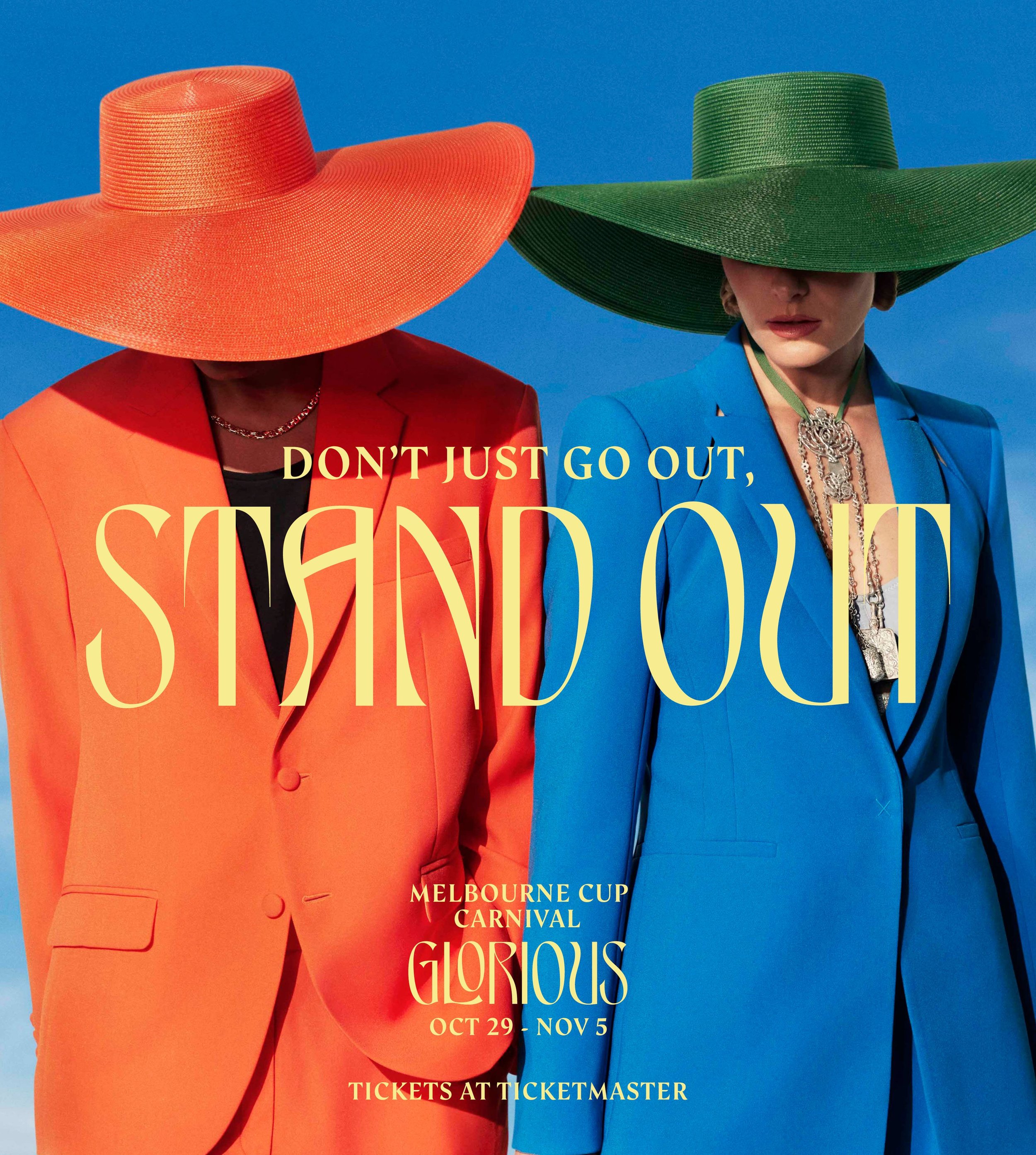 Two people wearing orange and green hats and blazers stand in front of a blue sky. Text reads: Don't just go out, stand out.