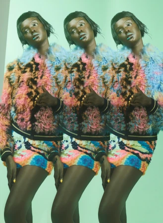 Fashion shot features three identical African American women in colorful faux fur jackets and sequined shorts against a light green background.